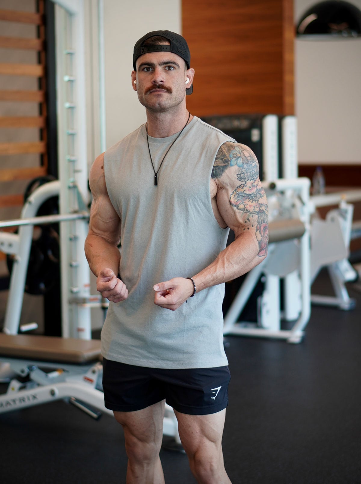 Coach standing in a gym with his earphones.